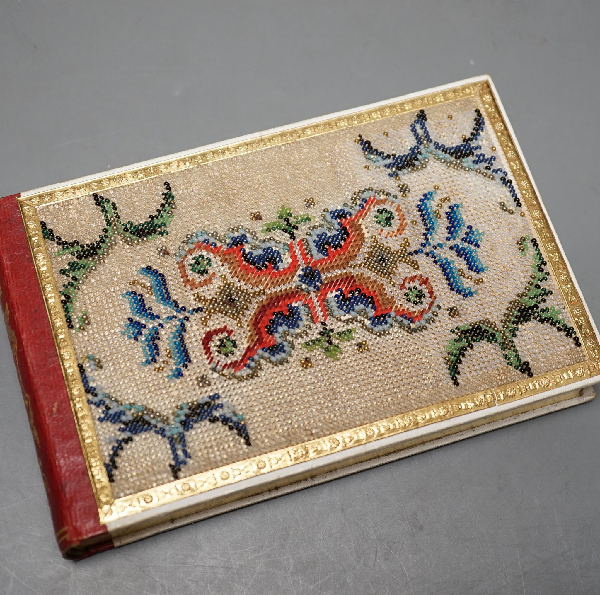 An Austrian beadwork cover souvenir album of watercolours and Berlin woolwork., 15 cms wide.